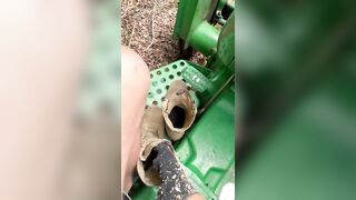 Dirty feet on tractor cutting wood