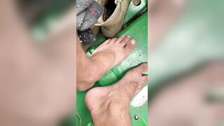 Dirty feet on tractor cutting wood