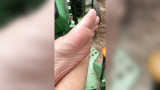 Dirty feet on tractor cutting wood