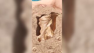 Girl Pissing on a large leaf that has fallen from a tree to the ground in Nature Park