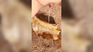 Girl Pissing on a large leaf that has fallen from a tree to the ground in Nature Park